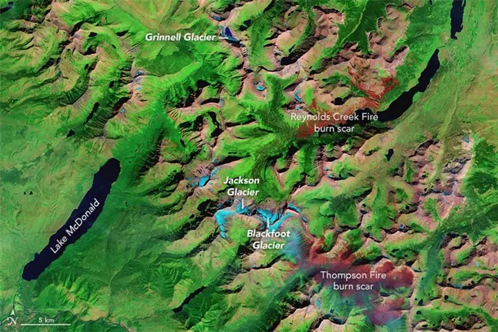 The same view in 2015, with visibly smaller light blue glacier patches and red burn scars from wildfires.